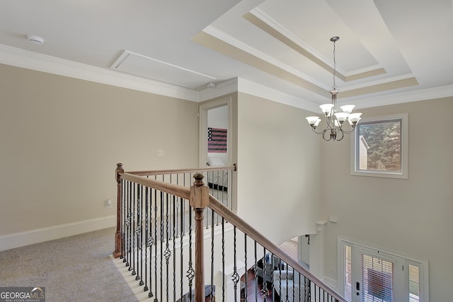 108 Village Pl, Newnan, GA 30265 - hall with attic access, an upstairs landing, ornamental molding, a raised ceiling, and a chandelier