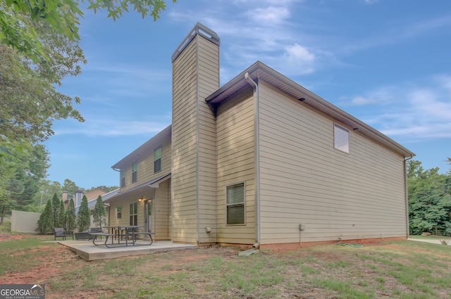 108 Village Pl, Newnan, GA 30265 - rear view of property featuring a chimney and a patio area