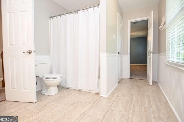 4714 Marc Ct SW, Lilburn, GA 30047 - bathroom featuring wood finished floors, a wainscoted wall, and a shower with curtain