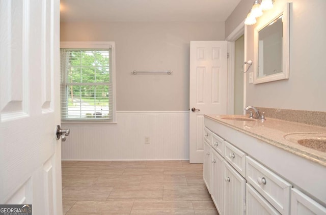 4714 Marc Ct SW, Lilburn, GA 30047 - bathroom with double vanity and a wainscoted wall