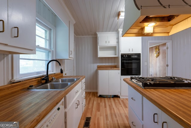 290 Mcree Dr, Camilla, GA 31730 - kitchen with black appliances, light wood-style flooring, white cabinets, butcher block counters, and wooden walls