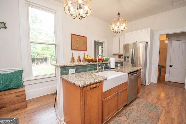 202 E Oak St, Luthersville, GA 30251 - kitchen with appliances with stainless steel finishes, a chandelier, light stone countertops, ornamental molding, and light wood-type flooring