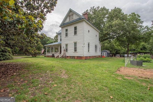 202 E Oak St, Luthersville, GA 30251 - view of property exterior featuring a storage unit, a chimney, a yard, and a porch