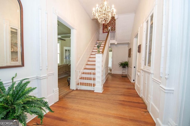 202 E Oak St, Luthersville, GA 30251 - entryway with stairway, a chandelier, light wood-type flooring, a decorative wall, and wainscoting