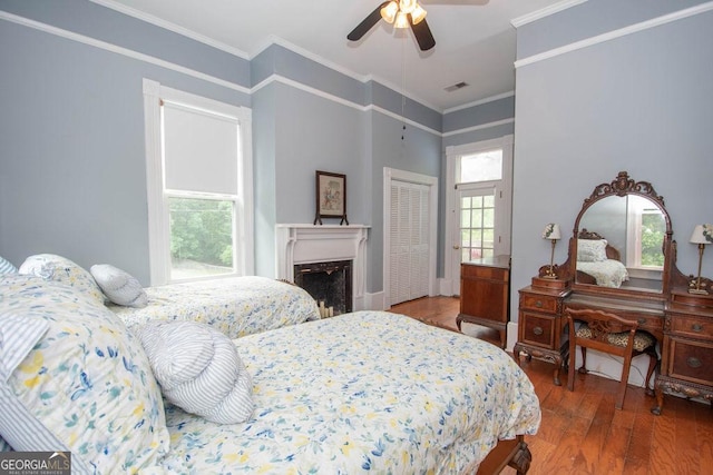 202 E Oak St, Luthersville, GA 30251 - bedroom featuring wood finished floors, multiple windows, ornamental molding, a fireplace, and a ceiling fan