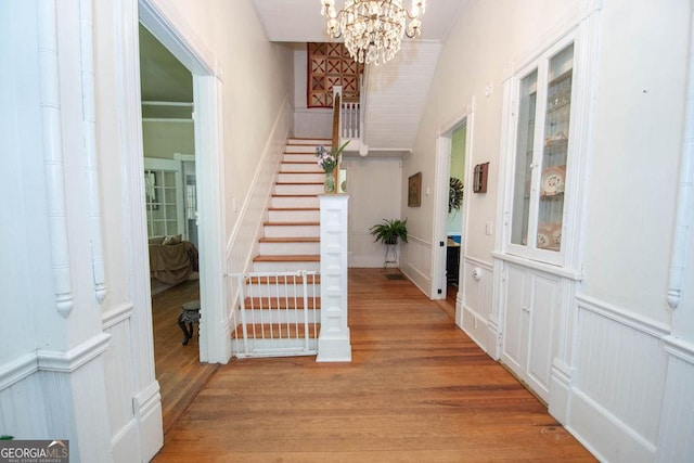 202 E Oak St, Luthersville, GA 30251 - entryway with stairs, a chandelier, wood finished floors, wainscoting, and a decorative wall