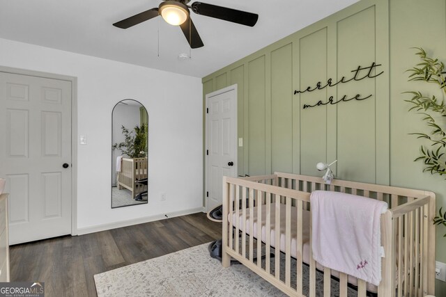 322 Pea Ridge Rd, Franklin, GA 30217 - bedroom with dark wood-style flooring, a crib, and ceiling fan