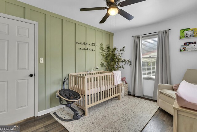 322 Pea Ridge Rd, Franklin, GA 30217 - bedroom featuring a nursery area, dark wood finished floors, and ceiling fan