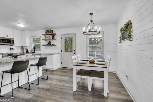 322 Pea Ridge Rd, Franklin, GA 30217 - dining room featuring healthy amount of natural light, a chandelier, dark wood-type flooring, ornamental molding, and wood walls