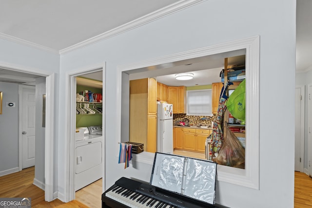 5400 Roswell Rd Apt L 6, Sandy Springs, GA 30342 - kitchen with freestanding refrigerator, crown molding, washer and dryer, light wood-type flooring, and tasteful backsplash