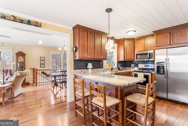 705 Laurel Ridge Dr, Ellijay, GA 30536 - kitchen featuring appliances with stainless steel finishes, wood finished floors, tasteful backsplash, a peninsula, and ornamental molding