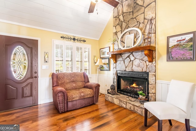 705 Laurel Ridge Dr, Ellijay, GA 30536 - living room featuring wainscoting, wood finished floors, lofted ceiling, a ceiling fan, and a stone fireplace