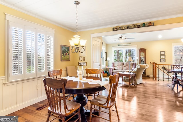 705 Laurel Ridge Dr, Ellijay, GA 30536 - dining room featuring light wood-style floors, ornamental molding, a chandelier, a ceiling fan, and a wainscoted wall