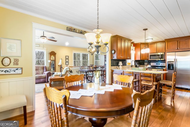 705 Laurel Ridge Dr, Ellijay, GA 30536 - dining area with a chandelier, wood-type flooring, crown molding, a ceiling fan, and wainscoting