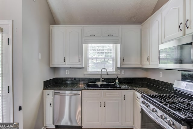 926 Masters Dr, Monroe, GA 30655 - kitchen with stainless steel appliances, white cabinetry, and lofted ceiling