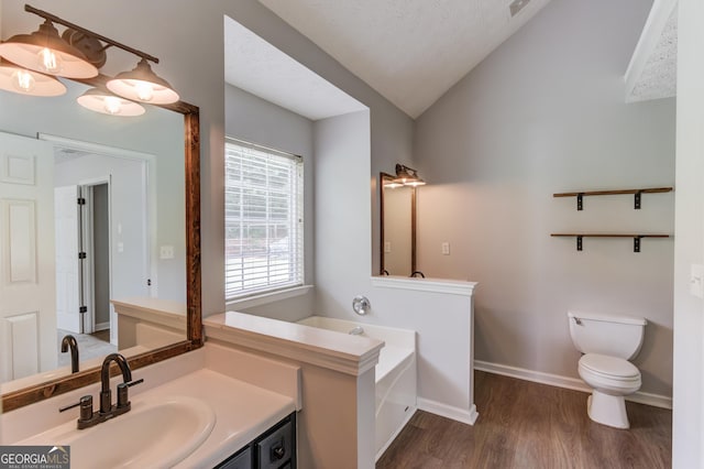 926 Masters Dr, Monroe, GA 30655 - bathroom with vaulted ceiling, vanity, wood finished floors, and a garden tub