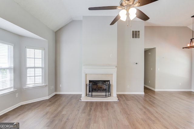 926 Masters Dr, Monroe, GA 30655 - unfurnished living room with ceiling fan, wood finished floors, a fireplace with raised hearth, a chandelier, and high vaulted ceiling