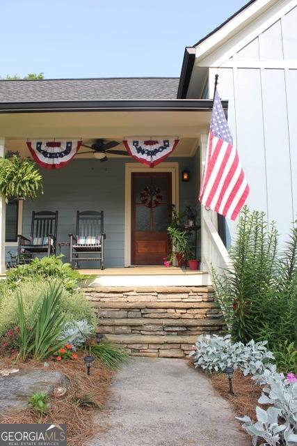 5880 Mulberry St, Austell, GA 30168 - entrance to property featuring a porch, a shingled roof, and a ceiling fan