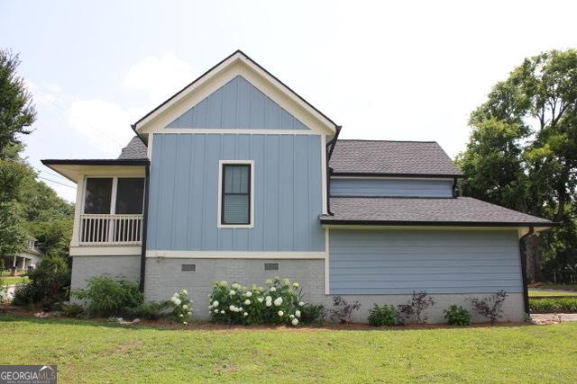 5880 Mulberry St, Austell, GA 30168 - view of side of property with a shingled roof, a yard, and board and batten siding