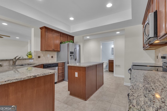 140 Olivia Ct, Fayetteville, GA 30215 - kitchen with stainless steel appliances, backsplash, light stone counters, a kitchen island, and recessed lighting
