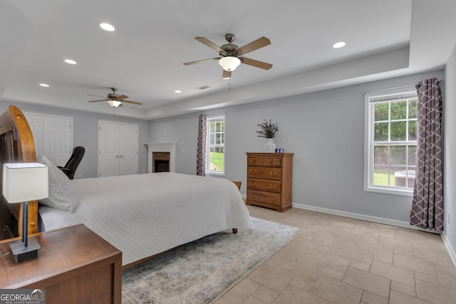 140 Olivia Ct, Fayetteville, GA 30215 - bedroom featuring multiple windows, two closets, recessed lighting, a raised ceiling, and a fireplace