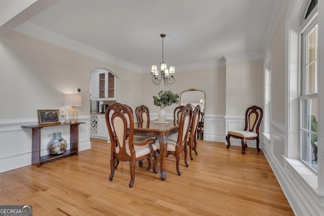 140 Olivia Ct, Fayetteville, GA 30215 - dining area featuring a chandelier, crown molding, light wood-style floors, and wainscoting