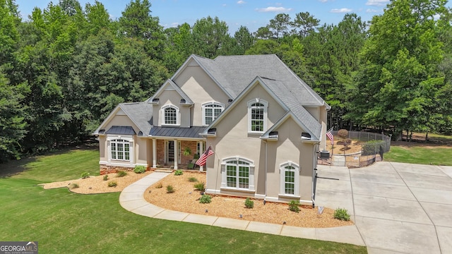 140 Olivia Ct, Fayetteville, GA 30215 - view of front of home featuring stucco siding, a standing seam roof, a front yard, roof with shingles, and a metal roof