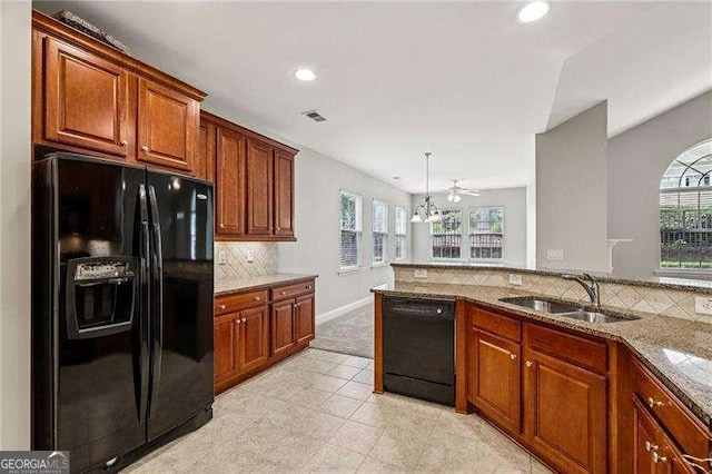 2721 Grapevine Cir Unit 1701, Cumming, GA 30041 - kitchen with black appliances, tasteful backsplash, recessed lighting, light stone countertops, and brown cabinetry