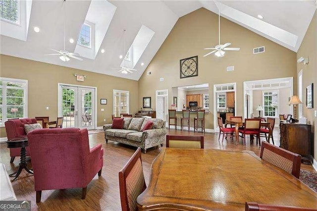 2721 Grapevine Cir Unit 1701, Cumming, GA 30041 - living area featuring a skylight, high vaulted ceiling, french doors, a ceiling fan, and wood finished floors