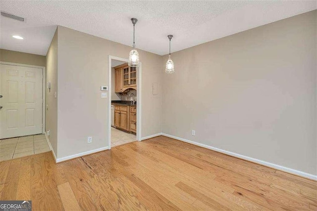 122 S Island Square Dr, Saint Simons, GA 31522 - unfurnished dining area with a textured ceiling, light wood finished floors, and recessed lighting