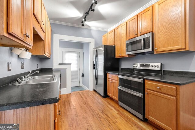 960 Taft Ave NE Unit 9, Atlanta, GA 30309 - kitchen featuring appliances with stainless steel finishes, rail lighting, light wood finished floors, dark countertops, and ornamental molding