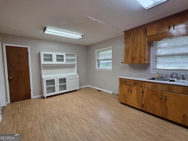 104 Denham St, Thomaston, GA 30286 - kitchen featuring light countertops, brown cabinets, light wood finished floors, and tasteful backsplash