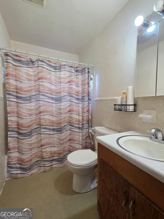 104 Denham St, Thomaston, GA 30286 - bathroom featuring tile walls, vanity, tile patterned flooring, and a wainscoted wall