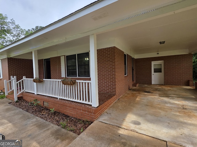 104 Denham St, Thomaston, GA 30286 - entrance to property featuring brick siding, a porch, and an attached carport