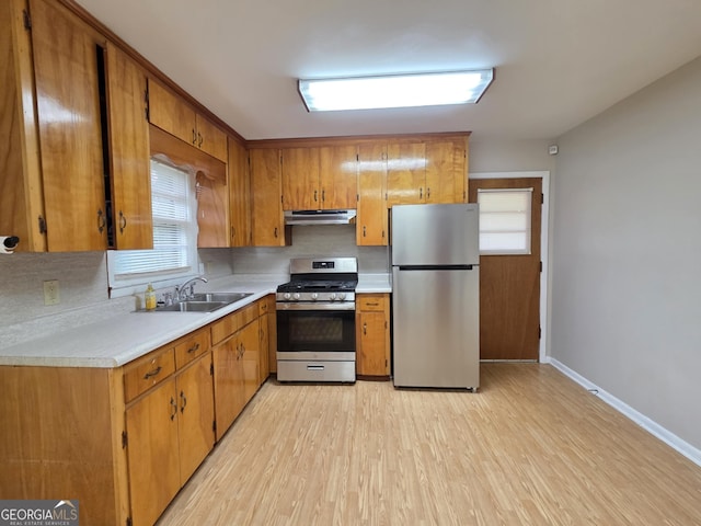 104 Denham St, Thomaston, GA 30286 - kitchen with stainless steel appliances, range hood, light countertops, brown cabinetry, and decorative backsplash