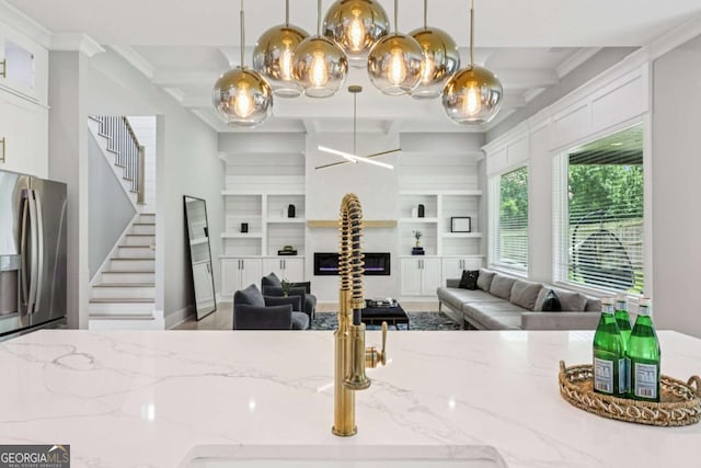 2243 Cain Cir, Dacula, GA 30019 - kitchen with stainless steel fridge with ice dispenser, open floor plan, decorative light fixtures, light stone counters, and beam ceiling