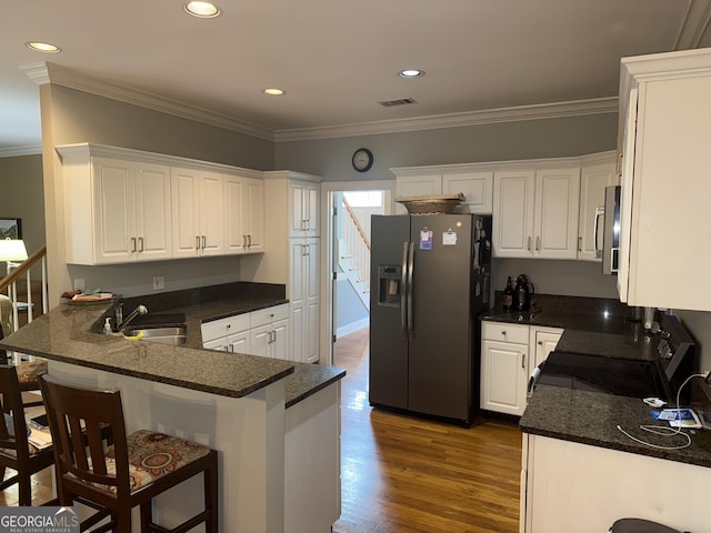 102 Cameron Pointe Dr, Lagrange, GA 30240 - kitchen with appliances with stainless steel finishes, dark wood-style flooring, a peninsula, white cabinets, and ornamental molding