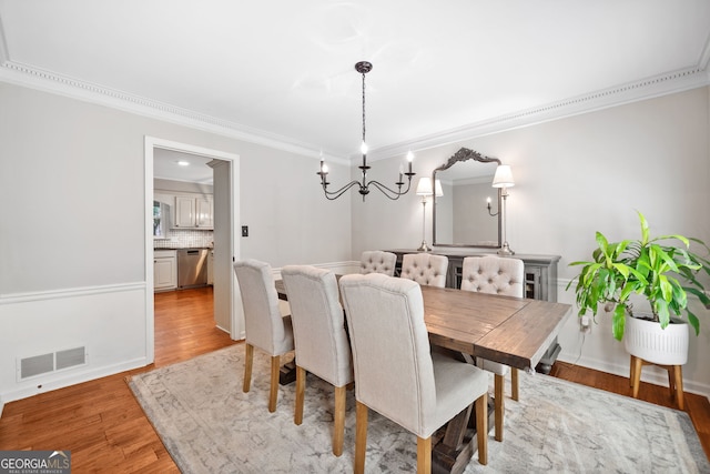 2502 Tritt Springs Trce NE, Marietta, GA 30062 - dining area featuring light wood-style flooring, a chandelier, and ornamental molding