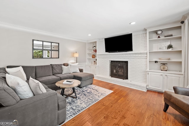 2502 Tritt Springs Trce NE, Marietta, GA 30062 - living area featuring built in shelves, light wood finished floors, a brick fireplace, recessed lighting, and ornamental molding