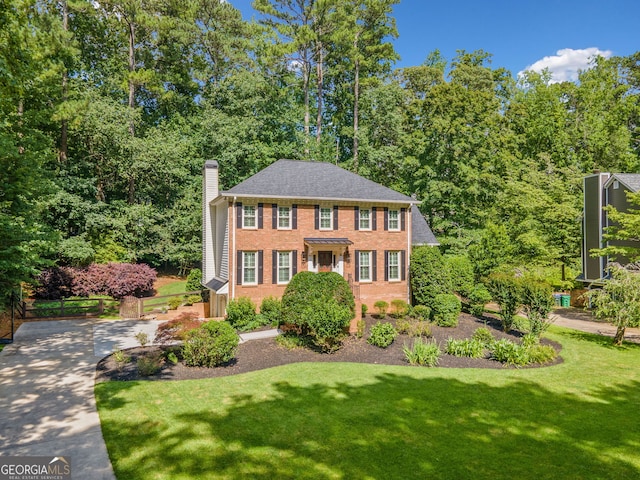 2502 Tritt Springs Trce NE, Marietta, GA 30062 - view of front facade featuring a chimney, brick siding, a front yard, and driveway