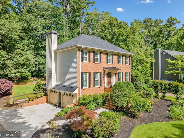 2502 Tritt Springs Trce NE, Marietta, GA 30062 - view of front of home with a chimney, an attached garage, brick siding, and driveway