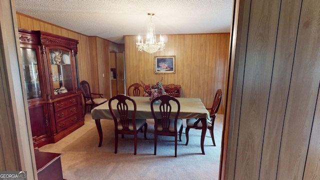 895 Ga Highway 57, Kite, GA 31049 - dining space with light colored carpet, a chandelier, wood walls, and a textured ceiling