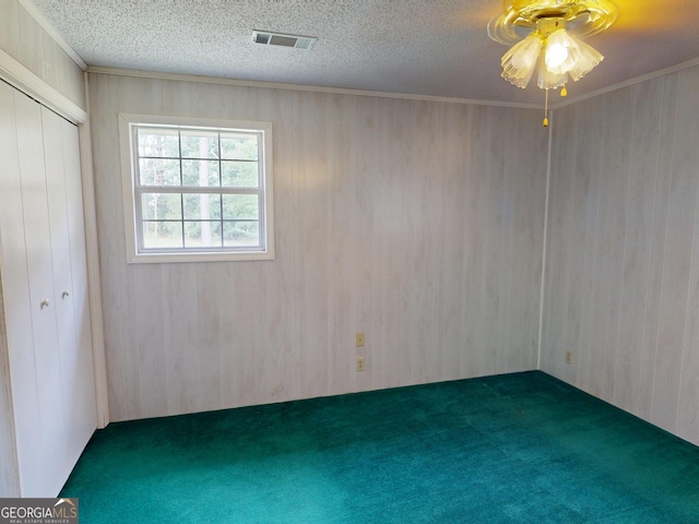 895 Ga Highway 57, Kite, GA 31049 - unfurnished bedroom with carpet, wooden walls, ornamental molding, a closet, and ceiling fan