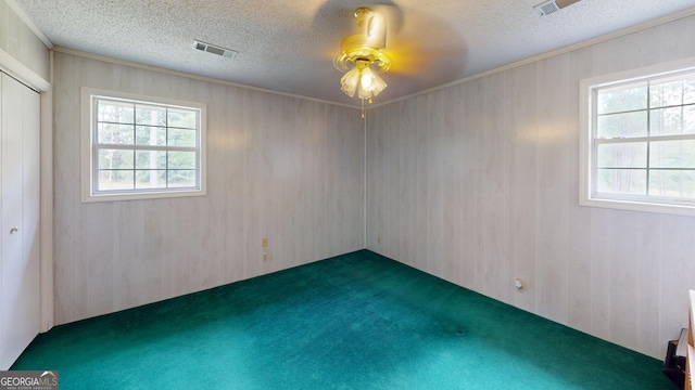 895 Ga Highway 57, Kite, GA 31049 - empty room featuring a textured ceiling, a ceiling fan, carpet floors, ornamental molding, and wooden walls