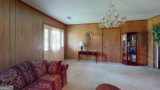 895 Ga Highway 57, Kite, GA 31049 - carpeted living area with a chandelier, wood walls, a textured ceiling, and ornamental molding
