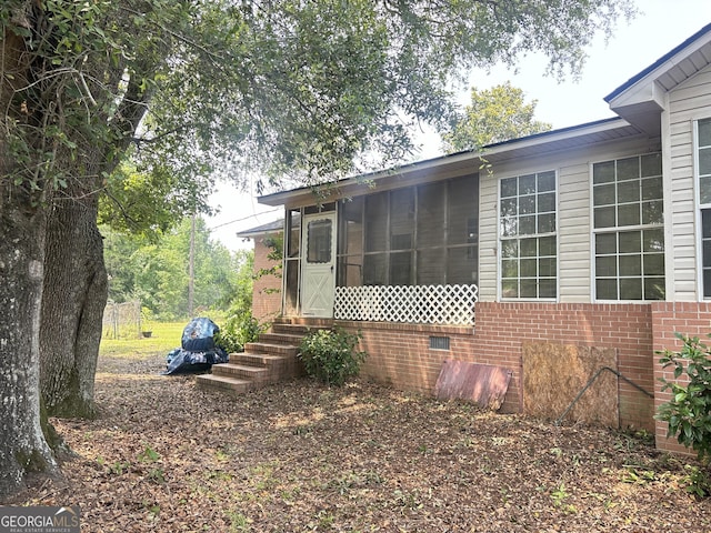 895 Ga Highway 57, Kite, GA 31049 - view of home's exterior with brick siding and a sunroom