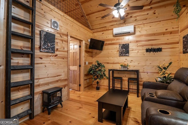 151 Rushmore Ln, Murphy, NC 28906 - living room featuring an AC wall unit, vaulted ceiling, a ceiling fan, a wood stove, and light wood finished floors