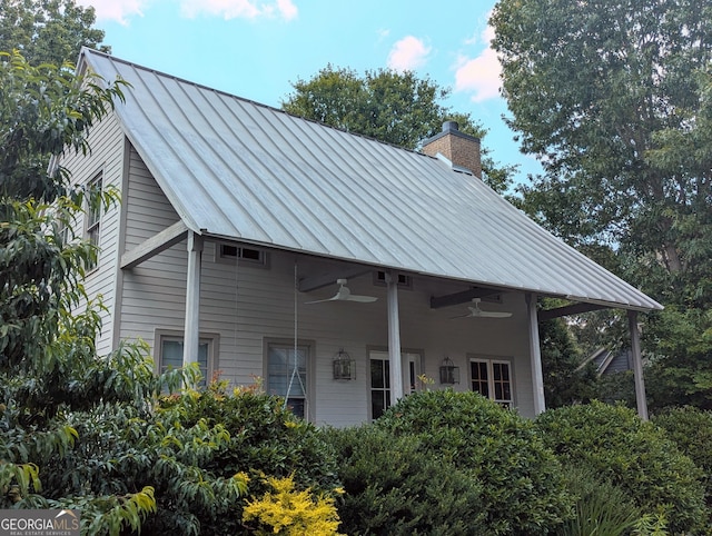 10540 Serenbe Ln, Chattahoochee Hills, GA 30268 - rear view of house featuring a standing seam roof, ceiling fan, a chimney, and a metal roof