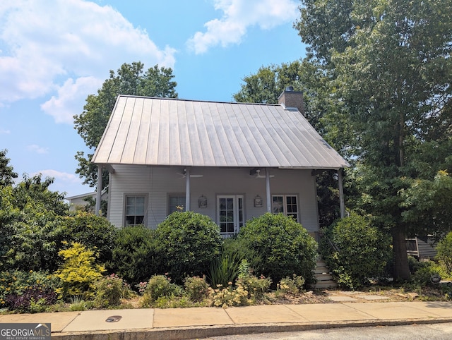 10540 Serenbe Ln, Chattahoochee Hills, GA 30268 - view of front of house featuring a metal roof, a chimney, and a standing seam roof