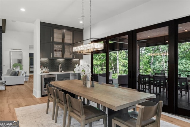4451 Shellie Ln, Oakwood, GA 30566 - dining space featuring beverage cooler, light wood-style flooring, recessed lighting, and bar